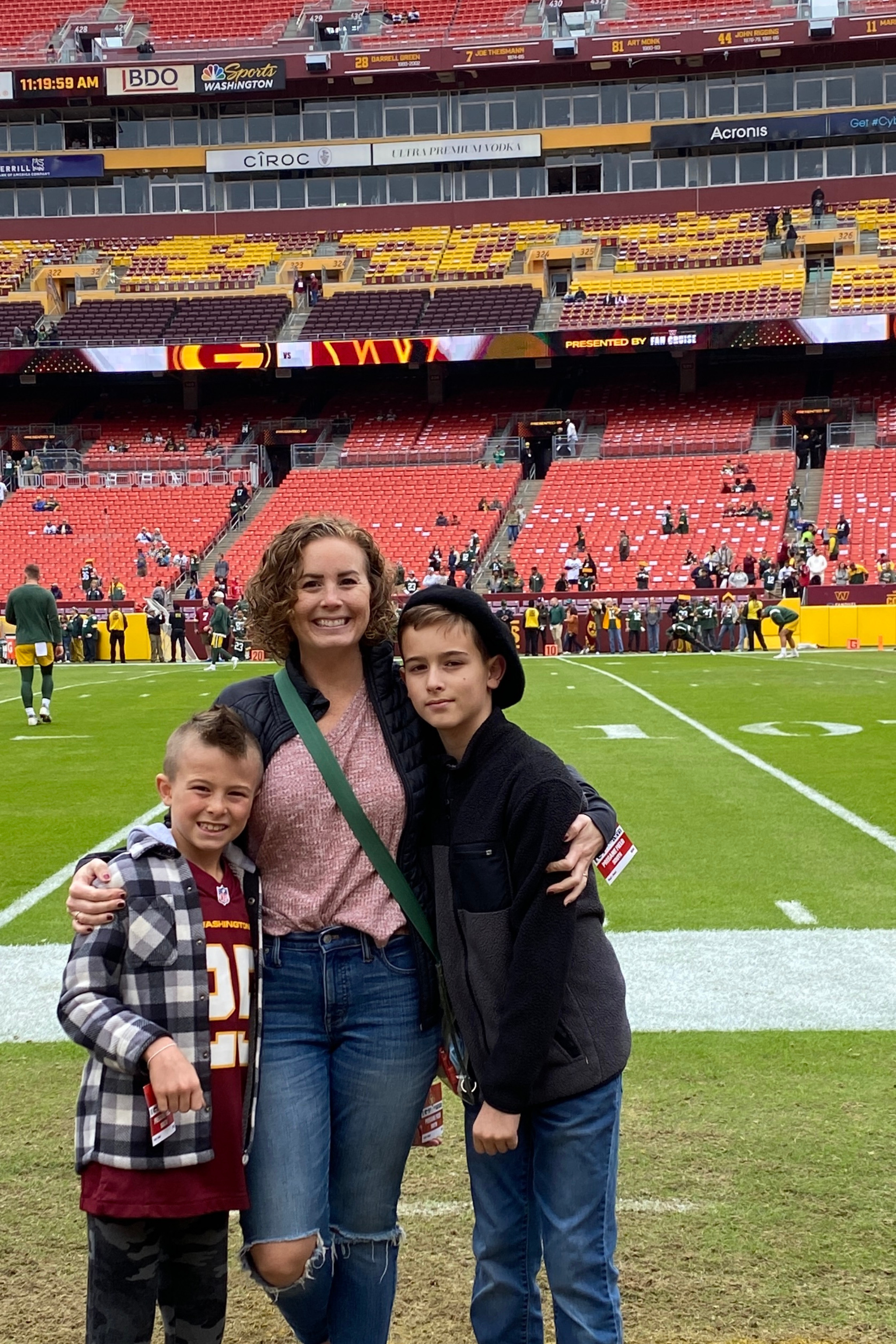 Maggie with his two boys standing in the Football field